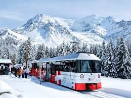 Le célèbre train à crémaillère du Tramway du Mont-Blanc progressant dans un paysage hivernal exceptionnel vers les sommets de Haute-Savoie.