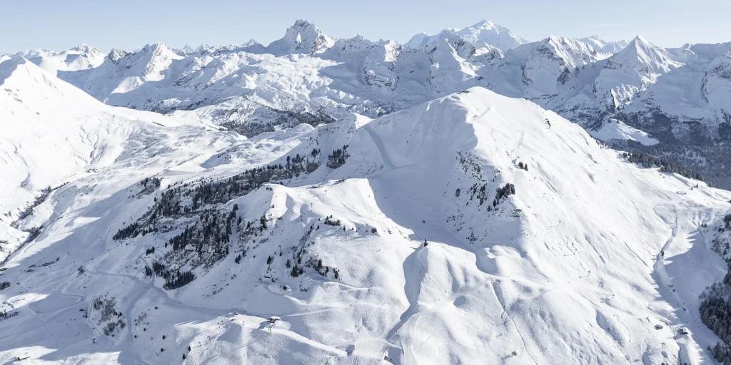 Vue aérienne d'un domaine skiable en Savoie, département leader des investissements dans les stations de ski françaises avec 230 millions d'euros en 2025.