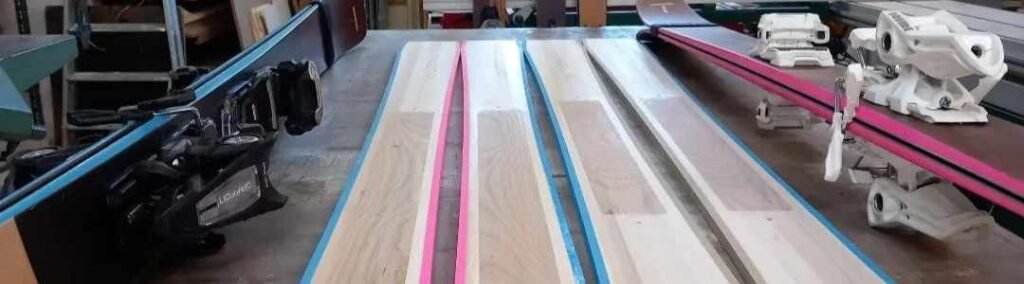 Rangée de skis modernes alignés dans la neige, illustrant l'aboutissement technologique de l'industrie française des sports d'hiver.