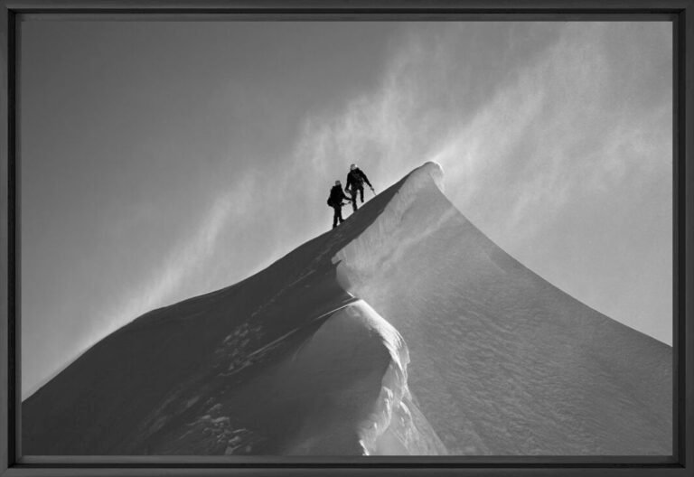 Alpiniste des années 1980 évoluant en équilibre précaire sur une arête vertigineuse du massif du Mont-Blanc, le visage battu par les vents.