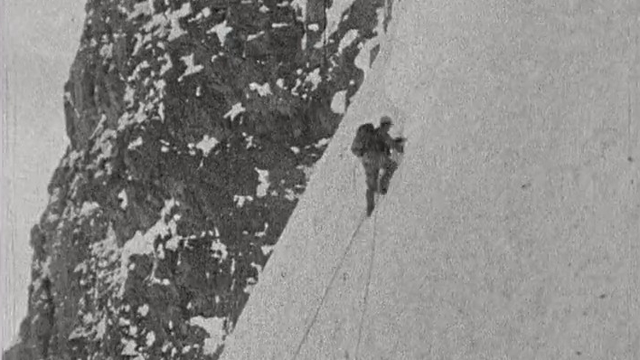 Alpinistes d'époque progressant sur le redoutable névé de l'Araignée Blanche, le passage le plus dangereux et exposé de la face nord de l'Eiger.