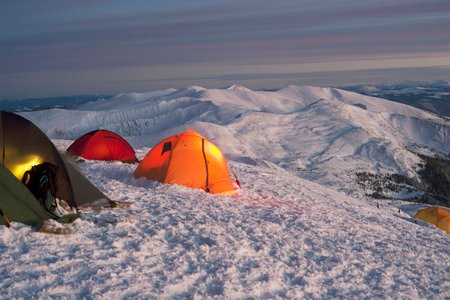 Une tente solitaire perdue dans l'immensité blanche d'un camp de base andin, balayée par les vents catabatiques.