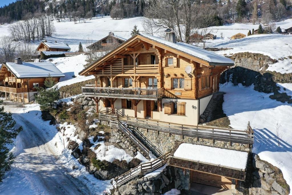 Chalets traditionnels savoyards en bois recouverts d'une épaisse couche de neige, typiques des stations facilement accessibles depuis Genève.
