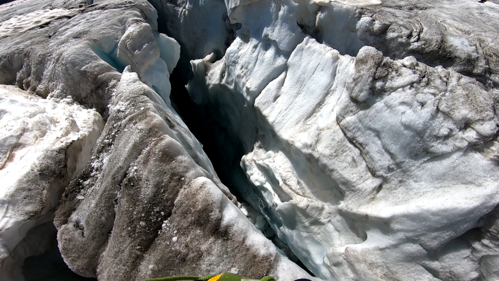 Plongée vertigineuse dans les entrailles d'une crevasse glaciaire, un abîme de glace bleue et noire engloutissant la lumière.