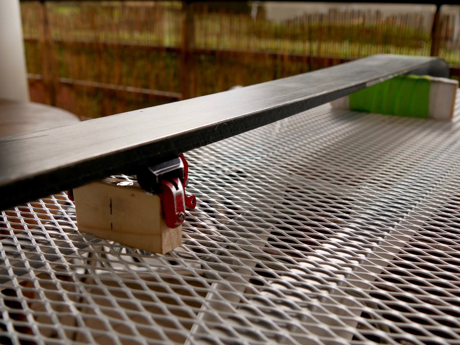 Ski bloqué dans un étau professionnel d'atelier, prêt à recevoir un affûtage des carres et un fartage à chaud.