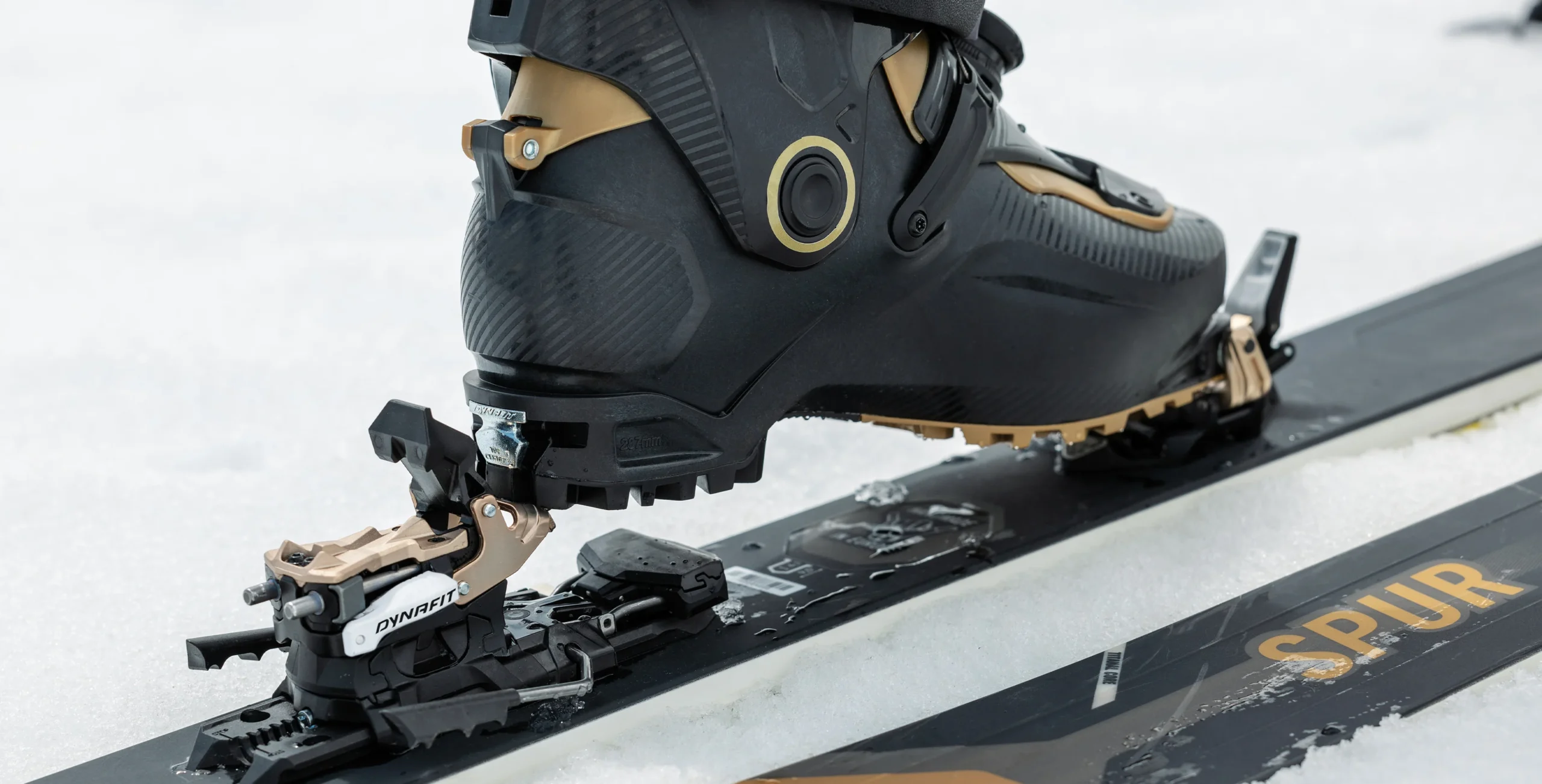 Gros plan sur la butée avant d'une fixation de ski enserrant fermement la chaussure, la pièce maîtresse pour la sécurité du genou.