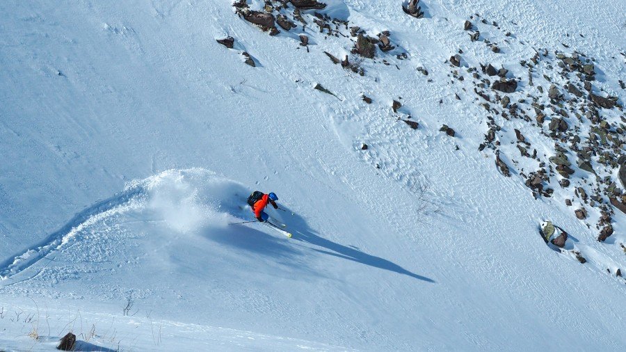 Un skieur s'enfonçant dans une poudreuse profonde et vierge sur les pentes sauvages des montagnes géorgiennes.