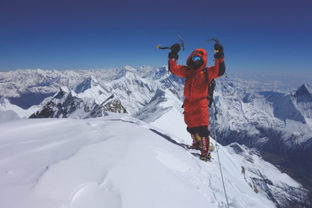 Grimpeur évoluant sur une arête vertigineuse et balayée par les vents dans la redoutable zone de la mort, au-delà des 8000 mètres.
