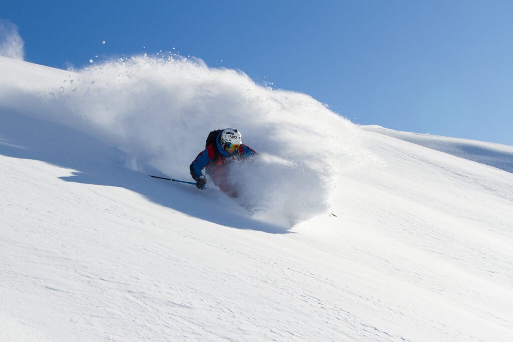 Skieur en difficulté dans une neige de printemps très humide et lourde, provoquant un dangereux effet ventouse sous les skis.