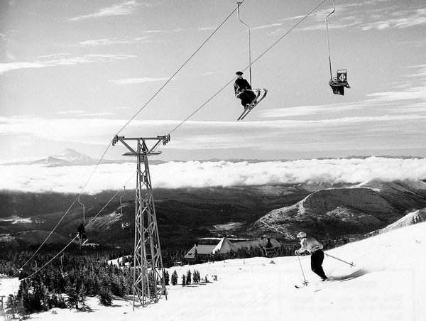 Gros plan sur les câbles et la machinerie métallique d'une ancienne remontée mécanique sous la neige dans les Alpes.