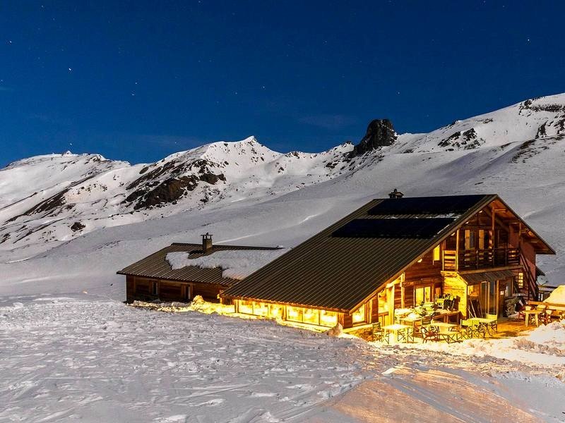 Refuge de haute montagne isolé dans la neige au crépuscule, l'étape indispensable des grands raids à skis sur plusieurs jours.
