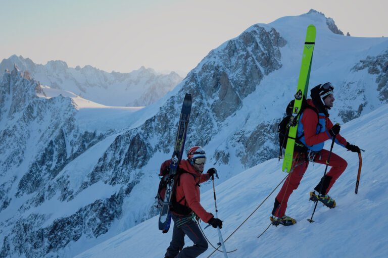 Skieur de randonnée en plein effort lors d'une ascension sur un glacier alpin sous le grand soleil du mois d'avril.