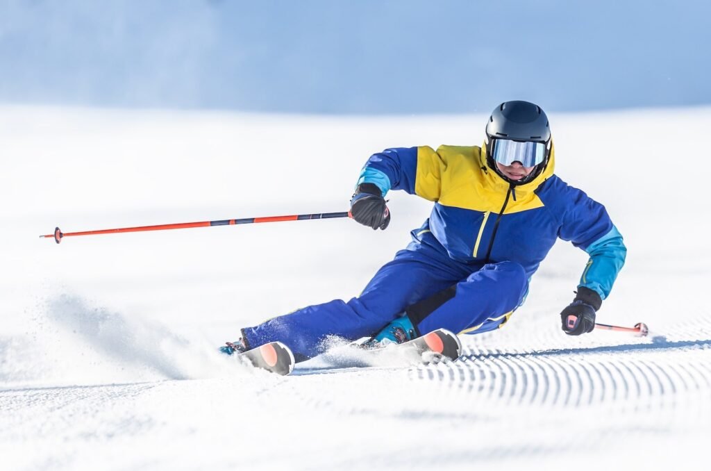Skieur alpin en pleine courbe (carving) sur une piste damée, démontrant l'efficacité redoutable des skis paraboliques contemporains.