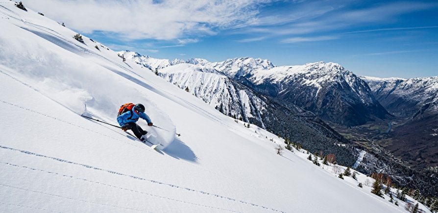 Skieur freeride soulevant un nuage de poudreuse fraîche lors d'un week-end express dans les Alpes du Nord.