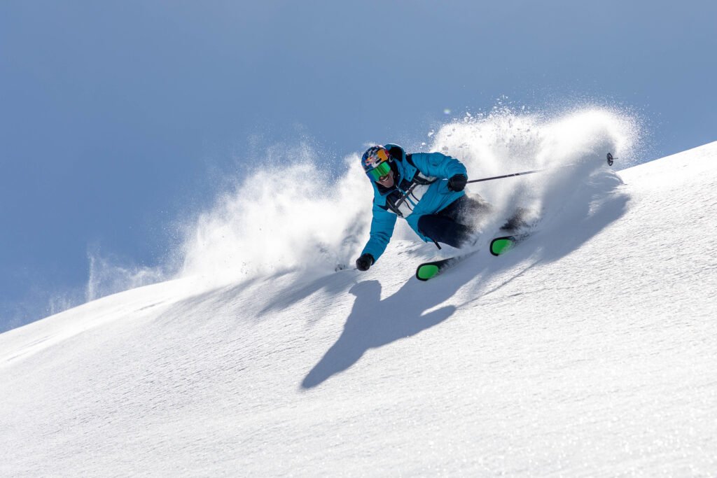 Skieur freeride utilisant des skis à patin très large pour flotter sur la poudreuse profonde sans s'enfoncer.