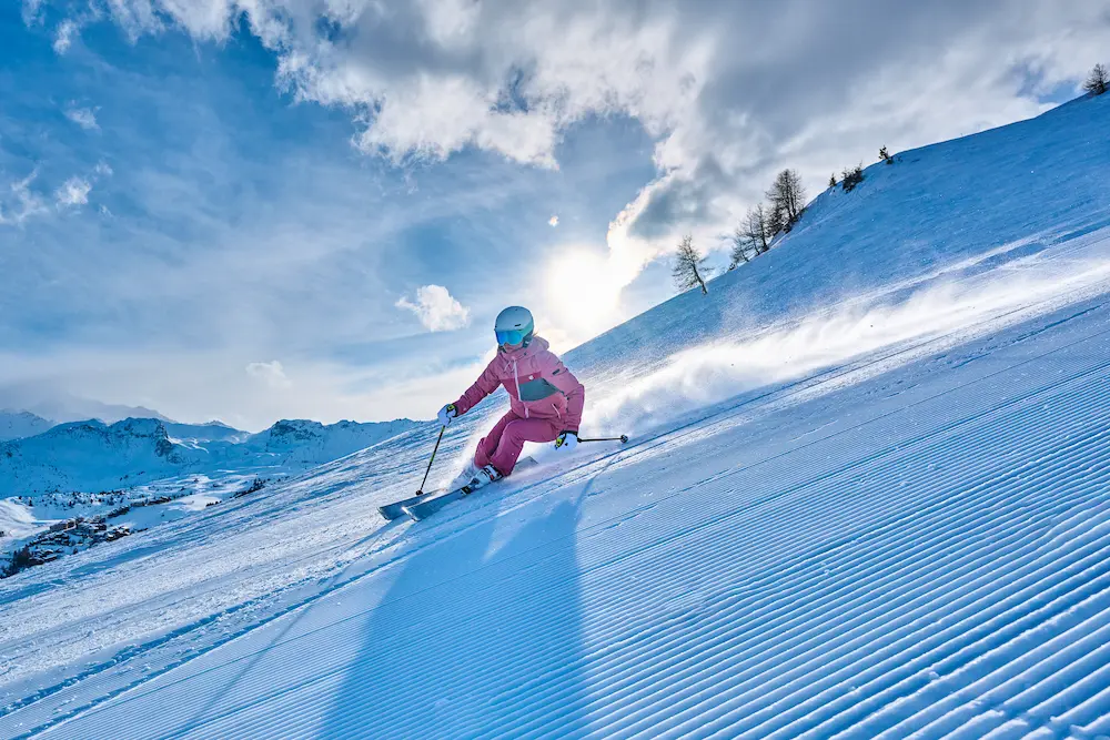 Skieur de randonnée contemplant le lever du soleil sur les cimes enneigées au petit matin, prêt à faire la première trace.