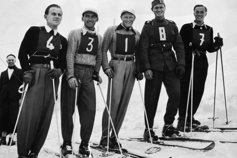 Skieur des années 1930 portant des vêtements amples et de lourds skis en bois, illustrant l'époque où Émile Allais a débuté sa carrière.