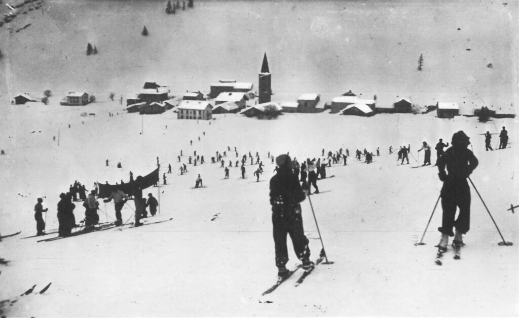 Des skieurs d'une autre époque profitant des premières pistes lissées par les machines, marquant le début du tourisme de masse en montagne.