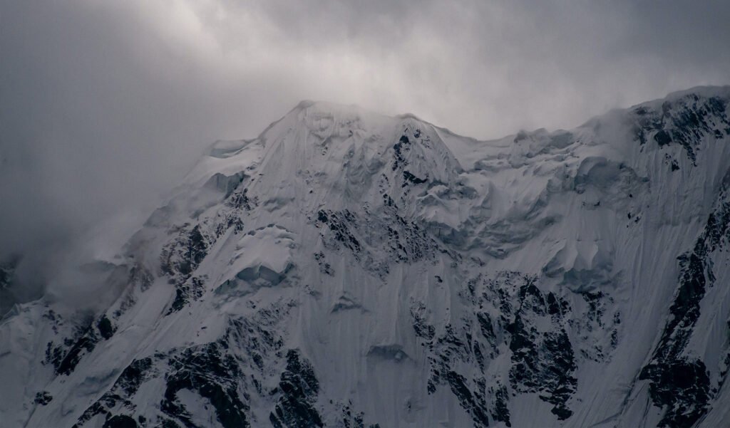 Cliché d'archive aux teintes ocre et vieux papier dévoilant l'imposante face du Nanga Parbat, l'un des sommets les plus meurtriers de l'Himalaya.