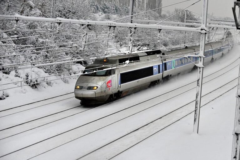 Un train fendant un paysage hivernal immaculé, symbole de la mobilité douce pour rejoindre les sommets alpins.