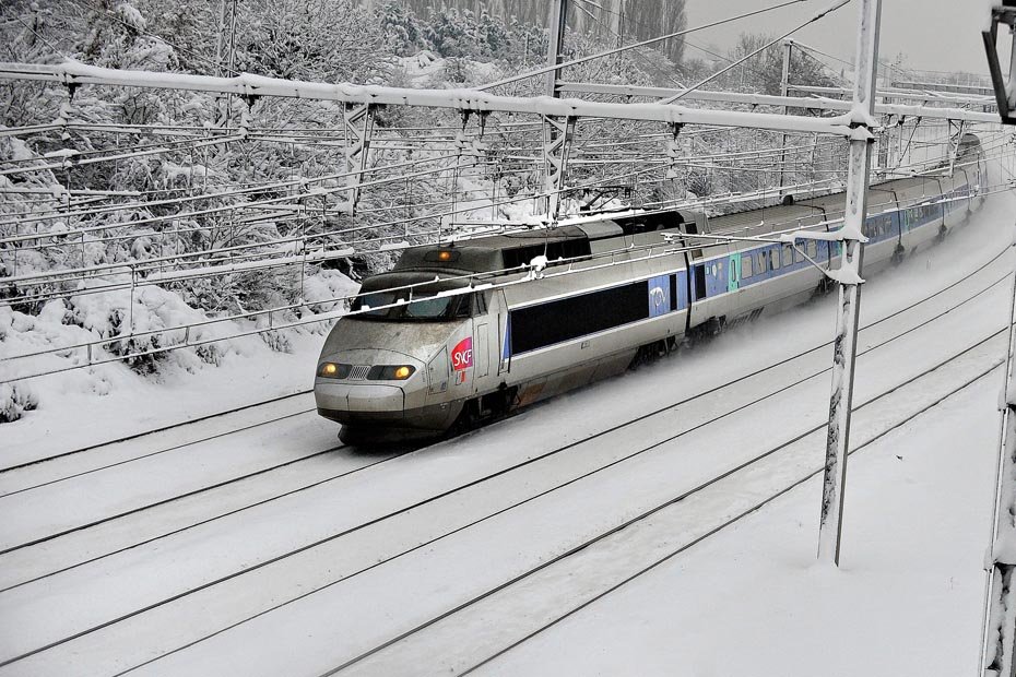 Un train fendant un paysage hivernal immaculé, symbole de la mobilité douce pour rejoindre les sommets alpins.
