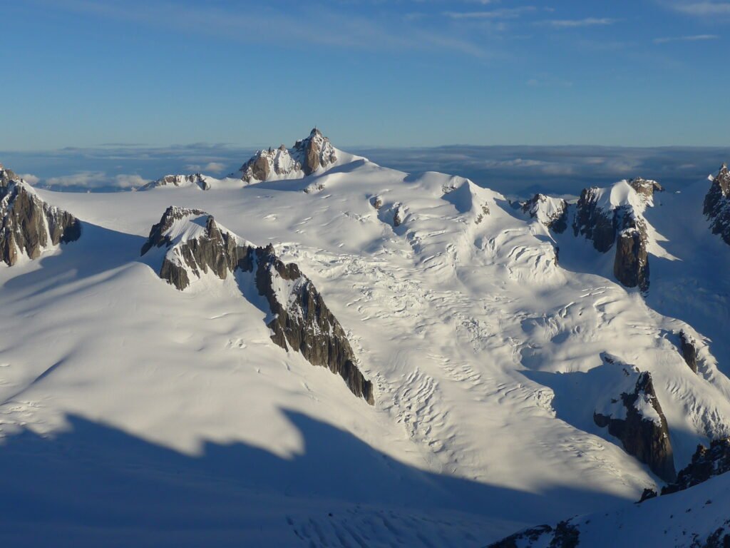 Groupe de skieurs évoluant dans l'immensité glaciaire de la Vallée Blanche à Chamonix, entourés de séracs et de crevasses.