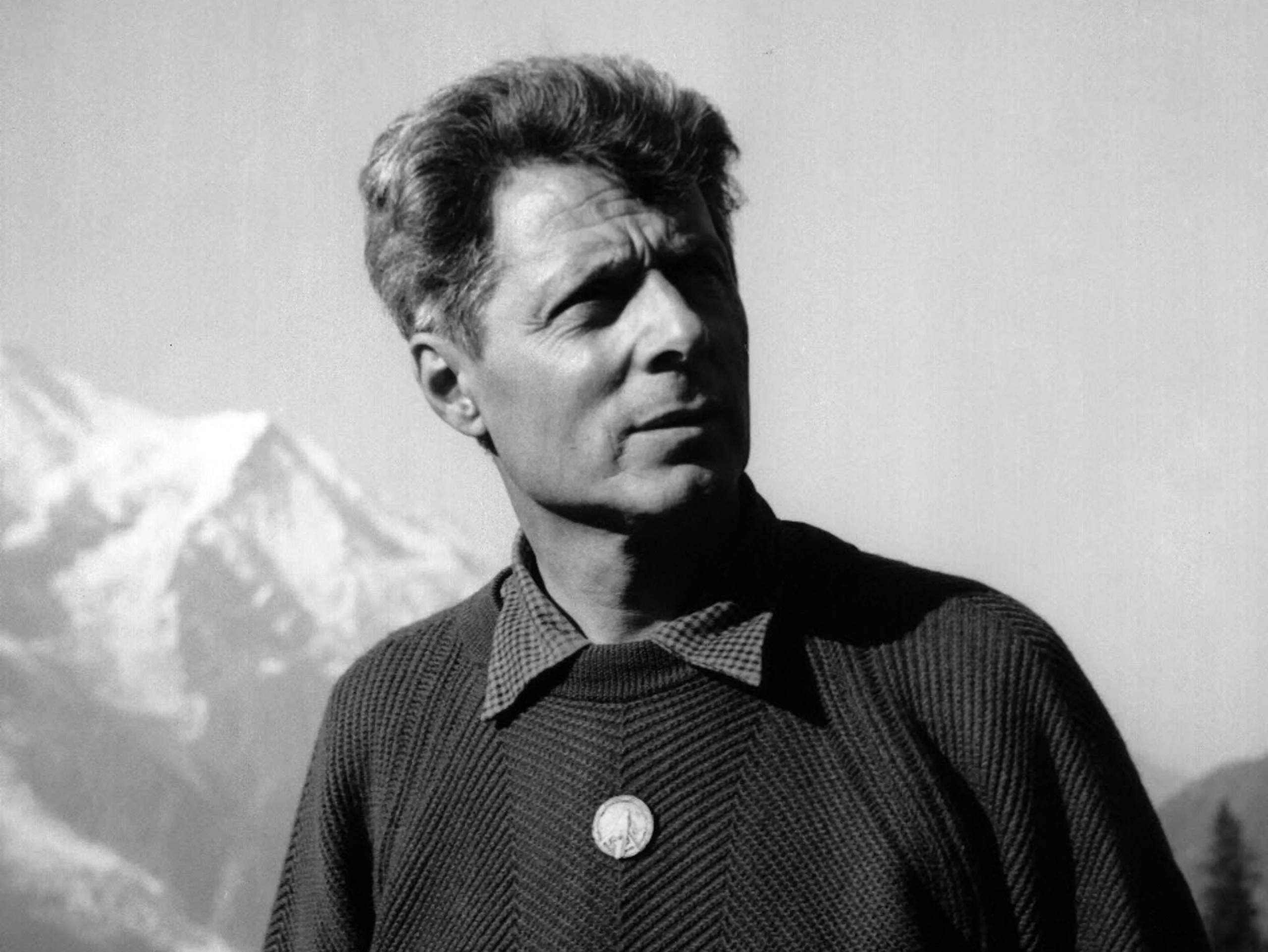 Vieux livre ouvert aux pages jaunies, évoquant les grands récits d'alpinisme et la littérature de montagne.