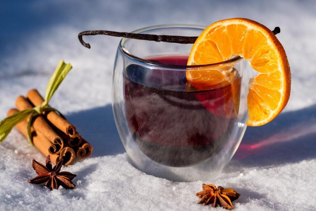 Tasses de vin chaud aux épices fumantes posées sur une table en bois l'hiver, le symbole absolu du réconfort après une journée sur les pistes.