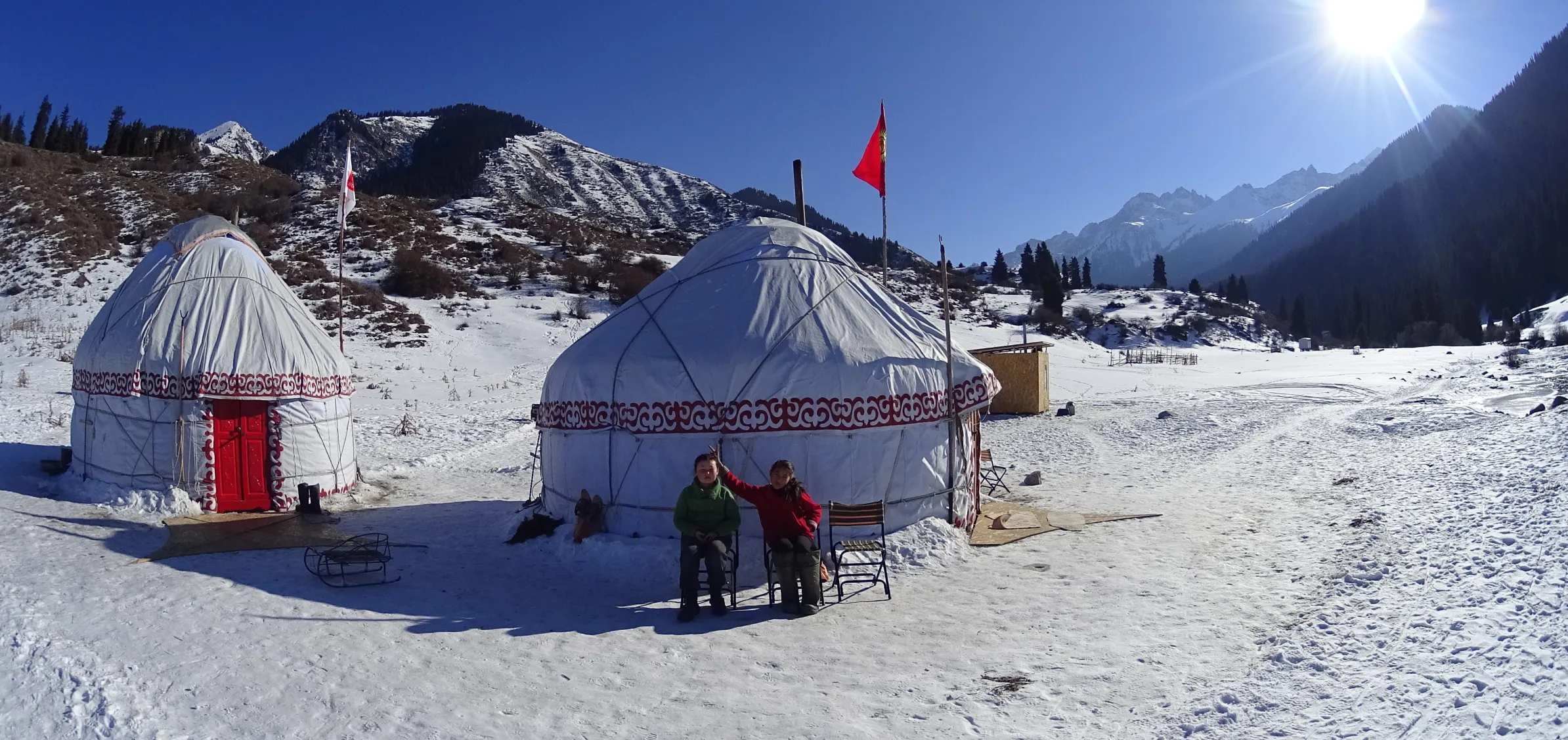Campement traditionnel de yourtes kirghizes, isolé dans une vallée reculée et lourdement enneigée des monts Tian Shan.