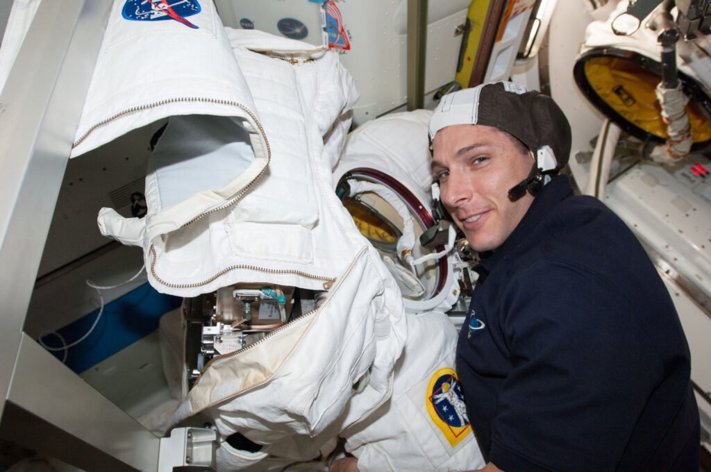 Un astronaute effectue des tests et réparations sur une combinaison EMU à bord de la Station spatiale internationale