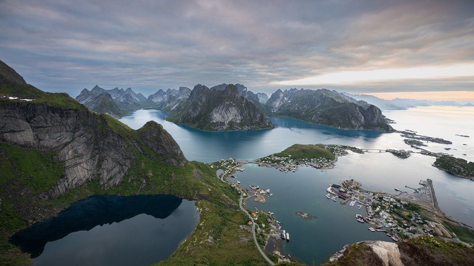 Vue aérienne de montagnes entourant un fjord et un village côtier