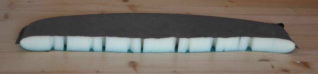 Coupe transversale d'un matelas isolant de randonnée montrant sa structure interne