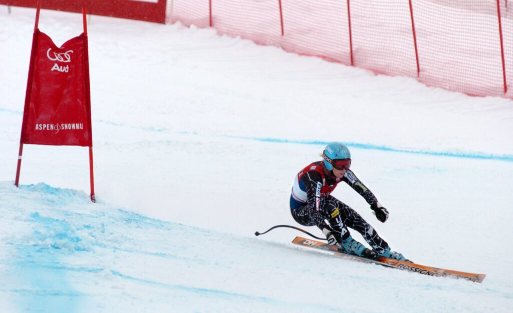 Skieuse en compétition inclinant fortement le corps dans un virage engagé